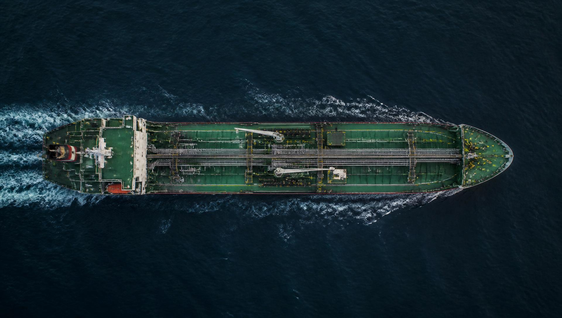 Aerial view of a red chemical tanker ship on turquoise water